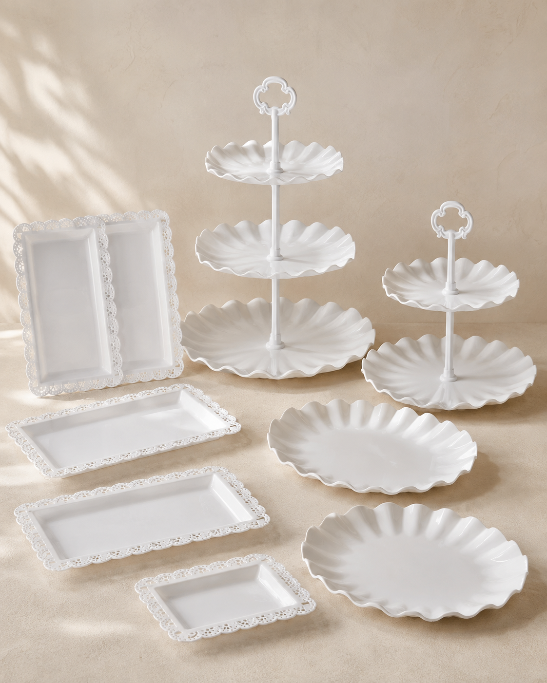 White tiered dessert stands and scalloped serving trays